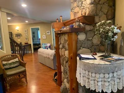 a room with a table and a stone wall at Shoreside Private room in Sechelt