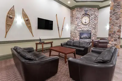 a living room with leather furniture and a fireplace at Ramada by Wyndham Hinton in Hinton