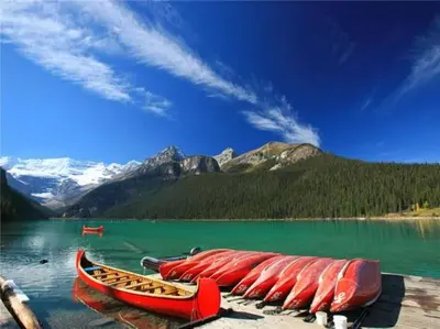 a group of red canoes sitting on top of a lake at The Mountain Loft in Canmore