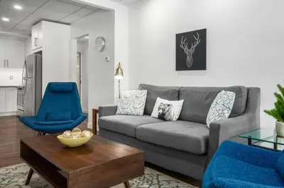 a living room with a couch and two blue chairs at Mountain Modern Hideaway in Canmore