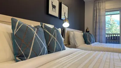 a bedroom with a bed with pillows and a window at Mountain Modern Hideaway in Canmore
