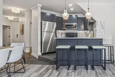 a kitchen with a refrigerator and a table and chairs at Mountain Vista Escape Downtown in Canmore