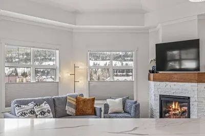 a living room with a couch and a fireplace at Mountain Vista Escape Downtown in Canmore