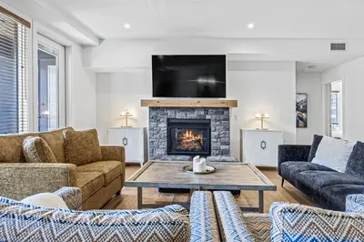a living room with couches and a fireplace at Serenity Villa at Tamarack in Canmore