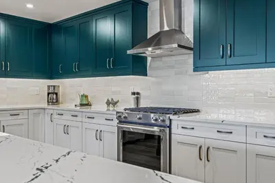 a kitchen with blue cabinets and a stove top oven at Serenity Villa at Tamarack in Canmore
