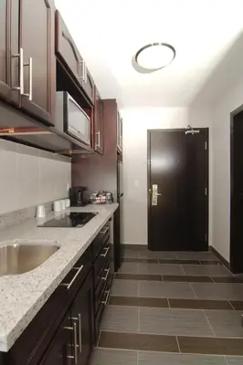 a kitchen with a black refrigerator in a room at Paradise Inn and Suites Redwater in Redwater