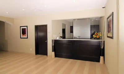 a living room with a kitchen with a counter at Paradise Inn and Suites Redwater in Redwater