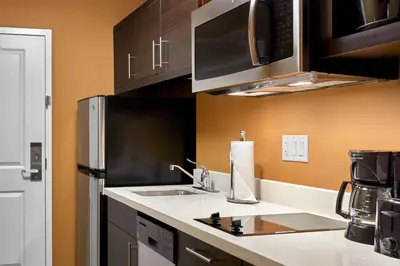 a kitchen with a sink and a refrigerator at TownePlace Suites by Marriott Fort McMurray in Fort McMurray