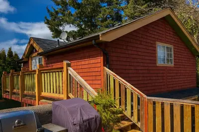 a small red house with a wooden deck at Charming 