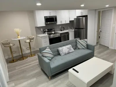 a living room with a couch and a kitchen at Brand new 2 Bedrooms modern guest suite with separate entrance in Calgary