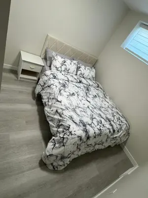 a bedroom with a bed and a night stand at Brand new 2 Bedrooms modern guest suite with separate entrance in Calgary
