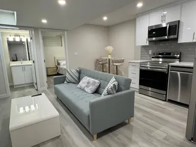 a living room with a couch and a kitchen at Brand new 2 Bedrooms modern guest suite with separate entrance in Calgary