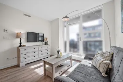 a living room with a couch and a tv at Stylish and Tranquil Retreat in Richmond City Center in Richmond