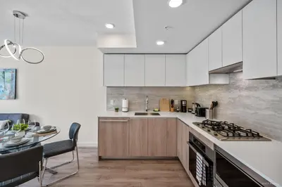 a kitchen with white cabinets and a dining table at Stylish and Tranquil Retreat in Richmond City Center in Richmond