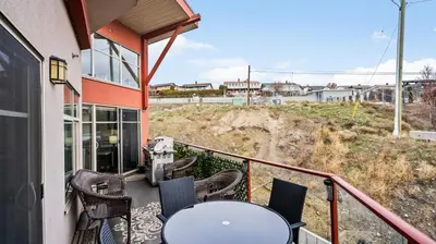 a balcony with a table and chairs on a building at Top Floor Lakeview Condo at Copper Sky 509 in West Kelowna