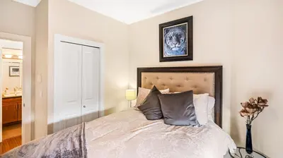 a bedroom with a bed and a vase of flowers at Top Floor Lakeview Condo at Copper Sky 509 in West Kelowna