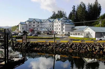 a large building with a marina next to a body of water at Quarterdeck Inn Port Hardy in Port Hardy