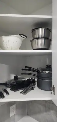 a kitchen shelf filled with pots and pans and utensils at Cozy One bedroom BSMT Apartment in Edmonton