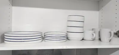 a white shelf with plates and vases on it at Cozy One bedroom BSMT Apartment in Edmonton