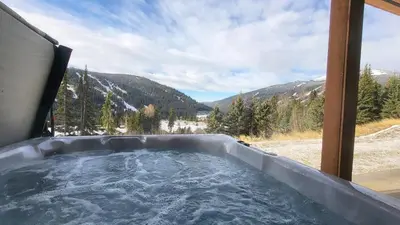 a hot tub with a view of the mountains at Powder Heights #22 townhouse in Sun Peaks