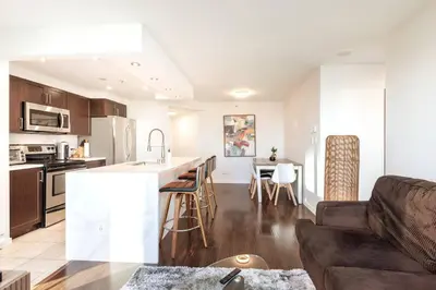 a kitchen and living room with a couch and a table at Luxury 2-bedroom condo beach side Yaletown in Vancouver