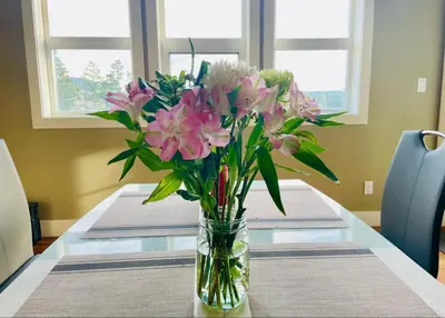 a vase filled with pink flowers on a table at Guest room with private bath in Langford in Victoria