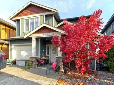 a house with a red tree in front of it at Guest room with private bath in Langford in Victoria