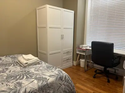 a bedroom with a bed and a desk with a computer at Guest room with private bath in Langford in Victoria