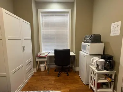 a room with a desk with a computer and a microwave at Guest room with private bath in Langford in Victoria