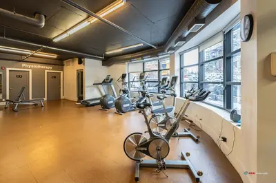 a gym with several treadmills and elliptical machines at Mountain Retreat Corner Suite -Pool - Hot Tub & Spa Escape in Canmore