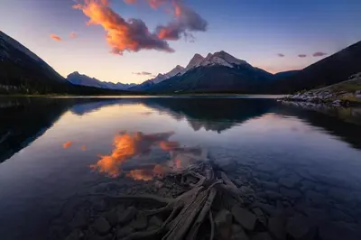 a view of a lake with a mountain in the background at Mountain Retreat Corner Suite -Pool - Hot Tub & Spa Escape in Canmore