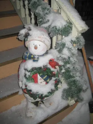 a snowman is standing next to a christmas tree at Phoenix House B&B in Stettler