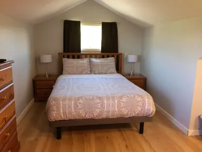 a bedroom with a bed with two night stands and a window at D'Angelo Winery Farm House in Penticton
