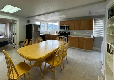a kitchen with a wooden dining table and chairs at D'Angelo Winery Farm House in Penticton