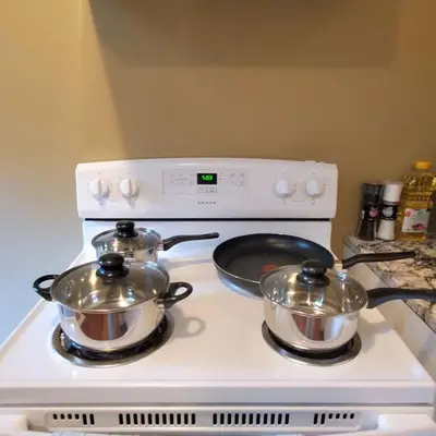 two pots and pans sitting on top of a stove at Spacious 2BR Near HWY 1-Heritage Park - Cultus Lake -Fishing! in Chilliwack