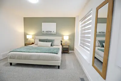 a bedroom with a bed and a mirror at BoHo Retreat with King Beds, Golf, Disney+, Near WEM in Edmonton