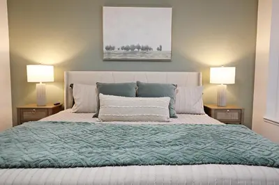 a bedroom with a large bed with two lamps at BoHo Retreat with King Beds, Golf, Disney+, Near WEM in Edmonton