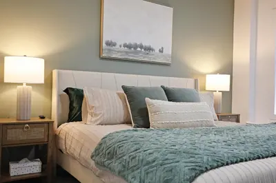 a bedroom with a bed with pillows and two lamps at BoHo Retreat with King Beds, Golf, Disney+, Near WEM in Edmonton