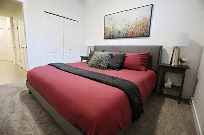 a bedroom with a large red bed with red pillows at Stylish Retreat with King Bed, Long Stays, WEM, Disney+ in Edmonton