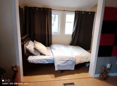 a small bedroom with a bed and a window at Cozy Red Deer Suite for 3 in Red Deer