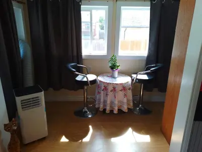 a room with a table and two chairs and a window at Cozy Red Deer Suite for 3 in Red Deer