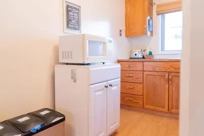 a kitchen with a microwave on top of a refrigerator at Cozy Red Deer Suite for 3 in Red Deer