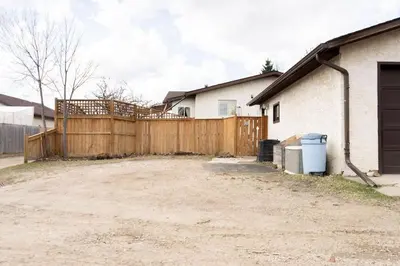 a wooden fence in front of a house at Cozy Red Deer Suite for 3 in Red Deer