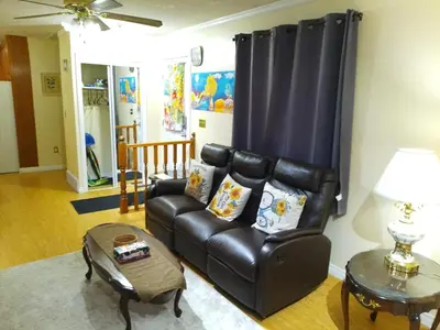 a living room with a leather couch and a table at Cozy Red Deer Suite for 3 in Red Deer