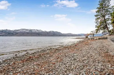 a rocky beach next to a body of water at Secluded Cabin On The Lake #7 in West Kelowna
