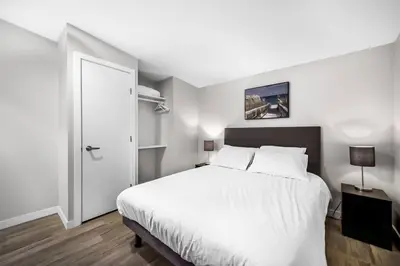 a bedroom with a white bed and a white door at Family-friendly Cottage with amazing views in West Kelowna