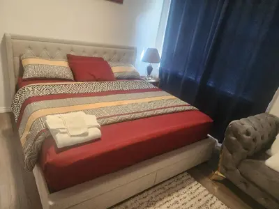 a bedroom with a large bed with a red blanket at Cozy one bedroom in Airdrie in Airdrie