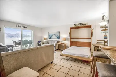 a bedroom with a bed and a living room at The Lakeside Condo #202 in West Kelowna