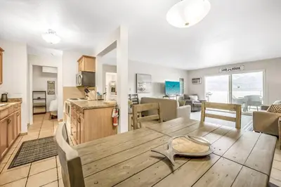 a kitchen and living room with a wooden table at The Lakeside Condo #202 in West Kelowna