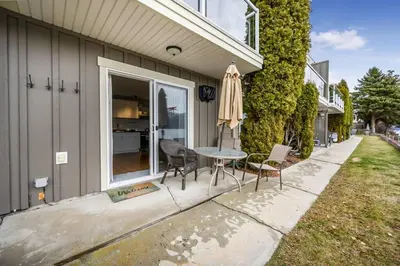a patio with a table and chairs and an umbrella at The Lakeside Cabin with wide outside space #105 in West Kelowna